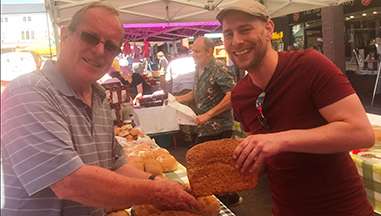 Stallholder passing bread to customer