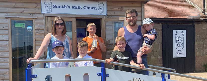 Family standing in front of Smith's Milk Churn